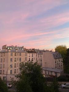 un groupe de bâtiments dans une ville au coucher du soleil dans l'établissement Duplex zen avec 2 chambres Paris, à Paris