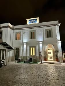 a white building with a sign on top of it at Academy Hotel in Fiumicino