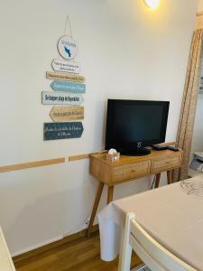 a room with a tv on a table with a desk with a television at Duplex 3 piscines (1 chauffée/couverte) 300m plage in Les Sables Vignier