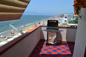 um computador portátil numa bancada numa varanda com vista para a praia em casa vacanze dei navigatori on the sea em Pontecagnano