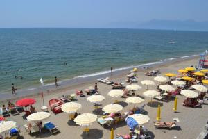 ポンテカニャーノにあるcasa vacanze dei navigatori on the seaの傘をさして浜辺に座る人々