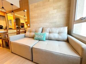 a couch in a living room with a blue pillow on it at STAY Blend SmartStyle in Goiânia
