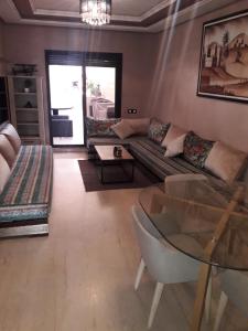 - un salon avec un canapé et une table en verre dans l'établissement Appartement cosy, terrasse , gueliz,, à Marrakech