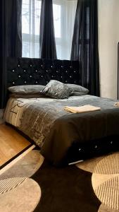 伦敦Comfy rooms. Shared East London Homestay.的卧室里有一张带黑色床头板的床