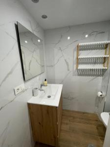 a white bathroom with a sink and a mirror at Apartamento las OLAS playa de levante in Benidorm