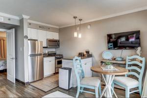 uma cozinha com uma mesa e cadeiras e um frigorífico em Oceanfront Condo in Myrtle Beach em Myrtle Beach