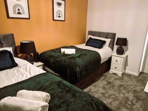 - une chambre avec 2 lits et 2 tables de chevet dans l'établissement 6 Guests * 4 Bedroom * Free Wi-Fi *Huntingdon, à Huntingdon