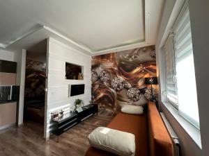 ein Wohnzimmer mit einer Wand mit Wandbild in der Unterkunft Füredi Apartman in Debrecen