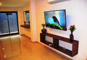 sala de estar con TV de pantalla plana en la pared en House and Suite Premium en Santa Fe