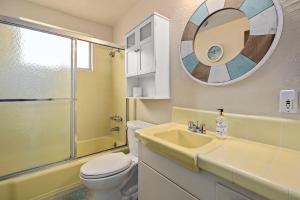 een badkamer met een wastafel, een toilet en een spiegel bij NEW! Ocean View Mid-Century Modern Beach House in Manhattan Beach