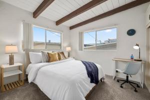 een slaapkamer met een bed, een bureau en een raam bij NEW! Ocean View Mid-Century Modern Beach House in Manhattan Beach