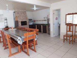 eine Küche mit einem Esstisch und einem Kamin in der Unterkunft SOBRADO COM PISCINA in Arroio do Sal
