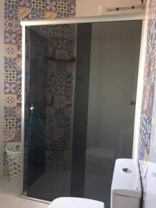 ein Bad mit einer Glasdusche und einem WC in der Unterkunft SOBRADO COM PISCINA in Arroio do Sal