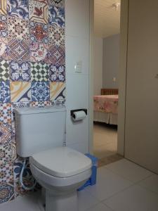 łazienka z toaletą i płytkami na ścianie w obiekcie SOBRADO COM PISCINA w mieście Arroio do Sal