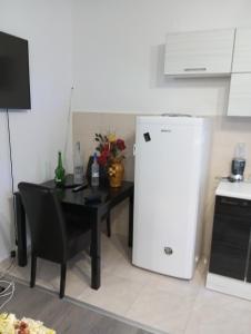 a small kitchen with a table and a white refrigerator at Apartman Old Town in Stolac