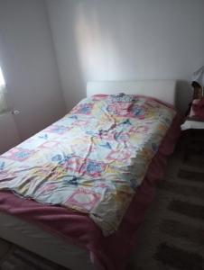 a bed with a colorful quilt on it in a room at Apartman Old Town in Stolac