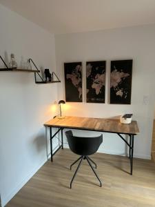 a desk in a room with a chair and paintings at Sunny House - Villa 4 chambres - Saint Genis Les Ollières in Saint-Genis-les-Ollières