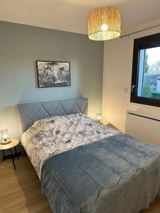 um quarto com uma cama e um lustre em Sunny House - Villa 4 chambres - Saint Genis Les Ollières em Saint-Genis-les-Ollières