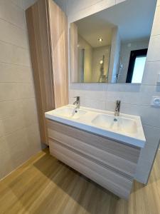 uma casa de banho com um lavatório branco e um espelho. em Sunny House - Villa 4 chambres - Saint Genis Les Ollières em Saint-Genis-les-Ollières