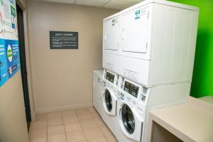 a laundry room with two washer and dryer machines at Holiday Inn Metairie New Orleans, an IHG Hotel in Metairie