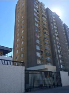 a tall building with a fence in front of it at Departamento frente la costa de Coquimbo in Coquimbo