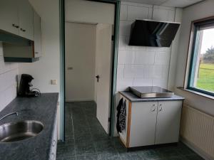 een kleine keuken met een wastafel en een wastafel bij Vakantiehuis Het Loar - Rust en Natuur in Vaassen