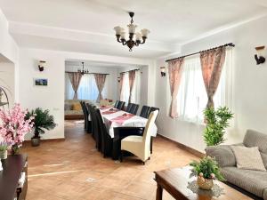 un soggiorno con tavolo da pranzo e sedie di Vila Anto a Şimon