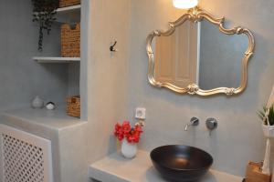 a bathroom with a sink and a mirror on the wall at Patmos Little Suites in Skala