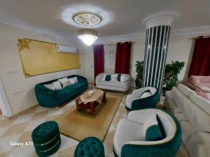 uma sala de estar com sofás e cadeiras e uma mesa em Deluxe Apartment Nasr city no Cairo