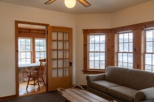 a living room with a couch and some windows at Sara Placid Inn & Suites in Saranac Lake