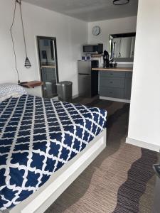 a bedroom with a blue and white bed and a kitchen at The Silverwood Lodge in Athol +10 photos