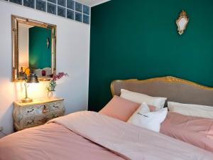 a bedroom with green walls and a bed with a mirror at Maison Papà, una casa per sentirsi a casa. in Vicenza