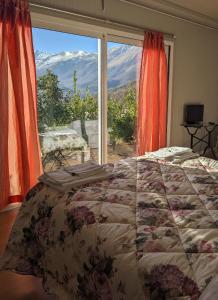 a bedroom with a bed and a large window at La Cittadella Dei Monti Sibillini in Montemonaco