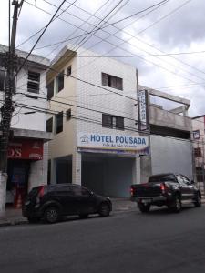 two cars parked in front of a hotel pueblosa at Hotel e Pousada Vila de São Vicente in São Vicente