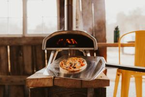 una pizza está siendo cocinada en un horno en Walnut A Frame TreeHouse with Hammock on Farm and Large Community Barn, en Newport 30 fotos más