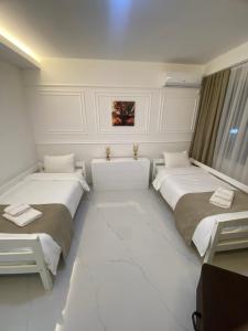 two beds in a room with white walls at Villa Jelena in Negotino