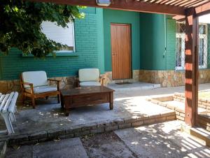 un patio con 2 sillas, una mesa y una puerta en Colibrí, en Piriápolis