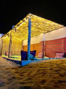 una tienda en la playa con luces encendidas en AlRaha Chalet en Badīyah