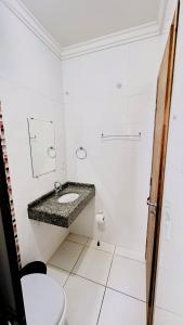 La salle de bains blanche est pourvue d'un lavabo et de toilettes. dans l'établissement GB Hotéis Foz, à Foz do Iguaçu