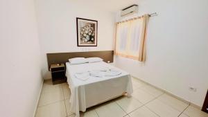 Cette chambre comprend un lit avec une table. dans l'établissement GB Hotéis Foz, à Foz do Iguaçu