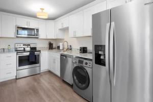 a kitchen with white cabinets and a stainless steel refrigerator at Affordable 1-BR by DMC Detroit in Detroit