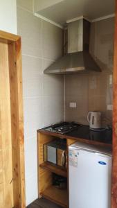 una piccola cucina con piano cottura e frigorifero di Cabañas Patagonia Indómita a Coihaique