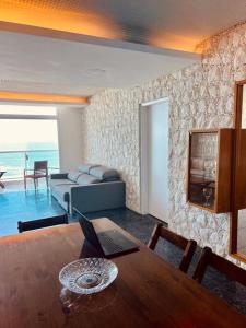 a living room with a table with a laptop on it at Apartamento frente mar Guarujá Pitangueiras pé na areia in Guarujá