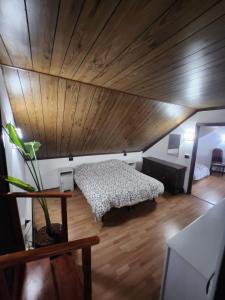 1 dormitorio con cama y techo de madera en Typical mountain mansarda close to Fiera Rho Milano MIND, en Pero