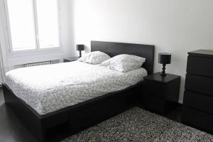 una camera con un letto con due comodini e due lampade di Appartement spacieux et lumineux - 15min de Paris Centre - Ideal Olympics a Sartrouville