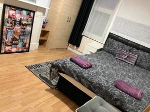 um quarto com uma cama com almofadas roxas em Comfy rooms. Shared East London Homestay. em Londres