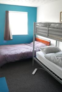 a bedroom with two bunk beds and a window at Blue Room Hostel Newquay in Newquay