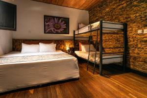 a bedroom with two bunk beds and a brick wall at Hotel Termales del Ruiz in Manizales