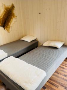 a room with two beds in a room with a wall at Stuga - Ulvereds Hjorthägn in Laholm