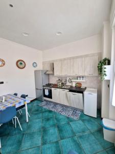 eine Küche mit grünem Fliesenboden und einem Tisch in der Unterkunft Il Nido di Nora - Apartment in Salerno